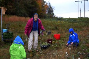 Volunteer Marty MacCleery helps Goodwillie students plant natives.