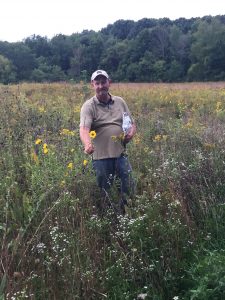 Prairie restoration project leader Mike Bruggink points out a Maximillian sunflower